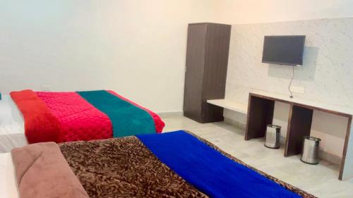 a room with two beds with a fireplace and a tv at Hotel Taj Signature in Tājganj