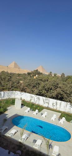 a view of a pool with lounge chairs at Nakhil Pyramids Resort in Cairo