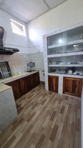 a kitchen with wooden cabinets and a wooden floor at Mayabini The Village Homestay in Bindukuri