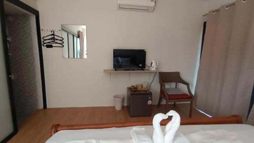 a room with a bed and a tv and a chair at ธัญญ์ รีสอร์ท หินดาด in Ban Pak Nam Chumphon