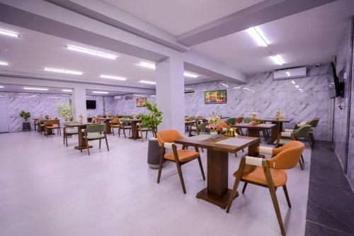 a restaurant with tables and chairs in a room at Floranta Hotel in Qarshi