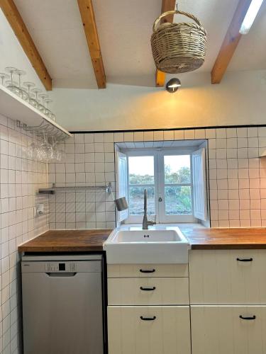 a kitchen with a sink and a window at Casa no Montinho in Ourique