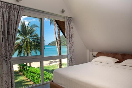 1 Schlafzimmer mit einem Fenster mit Blick auf den Strand in der Unterkunft Bikini Bottom Villa by Utalay Koh Chang in Ban Khlong Son