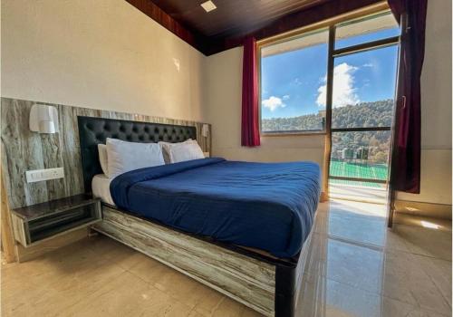 een slaapkamer met een groot bed en een groot raam bij Naini Hill View Boho in Nainital