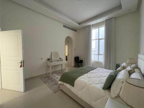 Villa في Sabkhah: غرفة نوم بها سرير كبير ومكتب