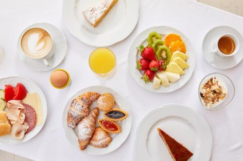 Una mesa blanca con platos de comida y tazas de café. en Villa Principe Giovanni, en Positano