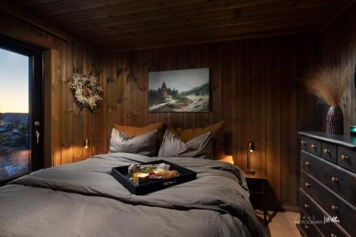 a bedroom with a bed with a tray of food on it at Ny og moderne hytte med sauna, jacuzzi og eget spillrom med biljard og dart Gratis elbillading og strøm inkludert i prisen in Flå
