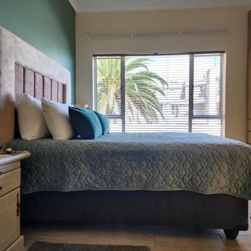 a bedroom with a large bed with a large window at Bella Vista in Mossel Bay
