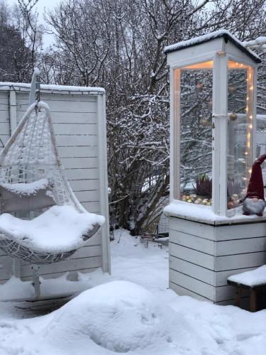a snow covered yard with a swing and a lantern at SnowCrystal home with free Jacuzzi and Sauna in Rovaniemi
