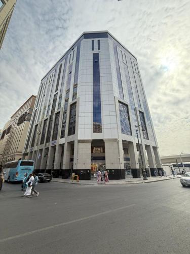 a large building with people walking in front of it at Ancyra Hotel - By Continent - فندق انكيرا in Medina