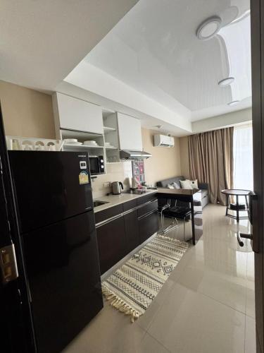 a kitchen with a black refrigerator and a table at Maikhao Beach Condominium in Mai Khao Beach