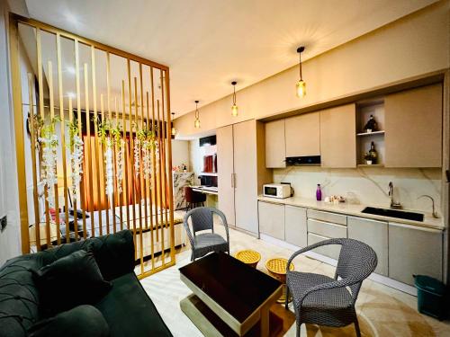 Nabhay Hotels and Resorts في غازي آباد: غرفة معيشة مع أريكة وكراسي ومطبخ