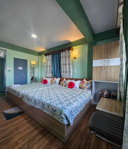 a large bed in a room with green walls at Sonali Megh in Darjeeling