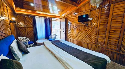 een slaapkamer met een bed in een kamer met houten wanden bij Naini Hill View Boho in Nainital