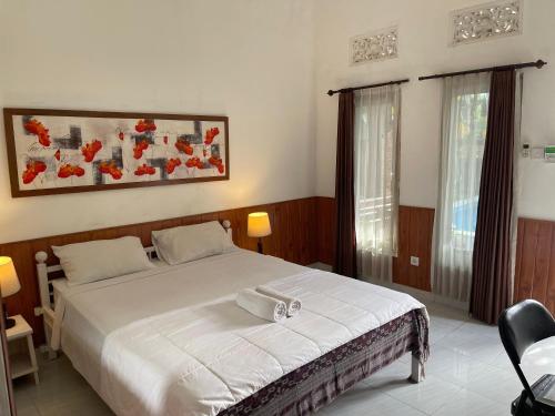 ein Schlafzimmer mit einem großen weißen Bett in einem Zimmer in der Unterkunft Casa D'Sami B & B in Ubud