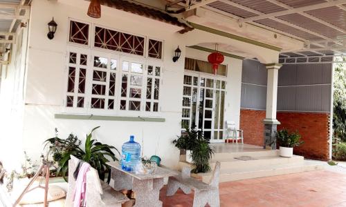 a patio of a house with tables and plants at BONNIE HOMESTAY Mui Ne in Mui Ne
