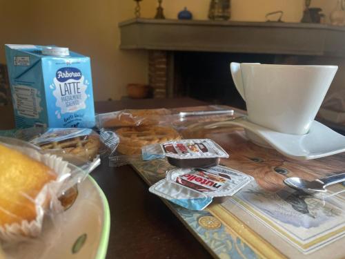 a table with pastries and a cup of coffee and a table with donuts at A casa di Mariarosaria in Pozzovetere