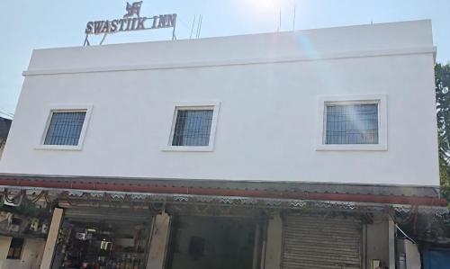 Swastiik Inn的一座白色建筑，顶部有一块招牌