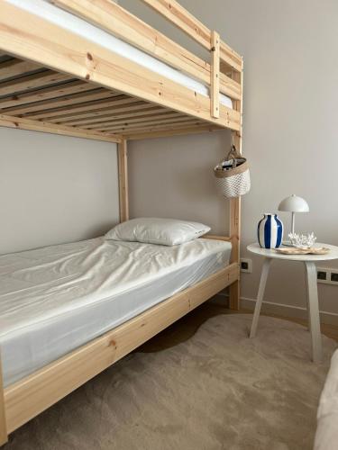 une chambre avec un lit superposé et une table dans l'établissement Windekind402, à La Panne