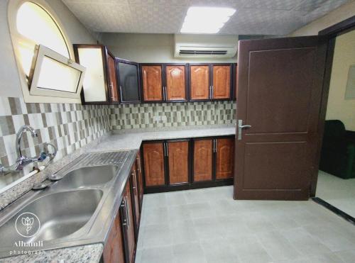 アル・アインにあるSolo comfort 205のシンクと木製のキャビネットを備えたキッチン