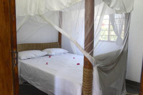 Postel nebo postele na pokoji v ubytování Sheba Cottages - Diani Beach