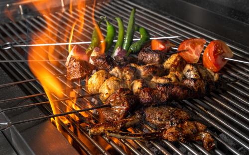 ein Haufen Fleisch und Gemüse auf einem Grill in der Unterkunft DoubleTree by Hilton Madinah Gate in Medina