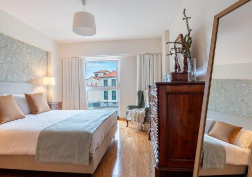 una camera da letto con un letto e una grande finestra di Funcho 91 - Spacious 100m2 Apt - Panoramic Views - Free Parking - Madeira a Funchal