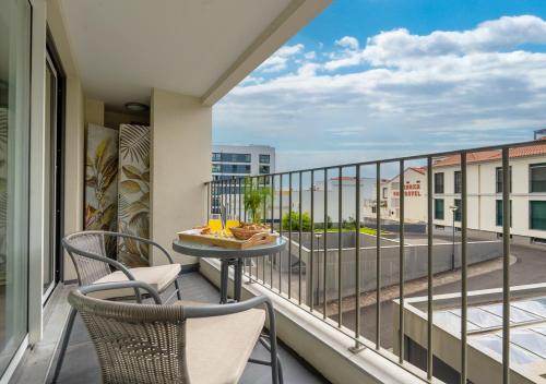 un balcone con sedie e un tavolo su un balcone di Funcho 91 - Spacious 100m2 Apt - Panoramic Views - Free Parking - Madeira a Funchal