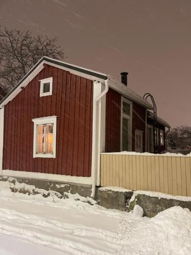 Captains Cabin, Old Town, Kokkola في كوكولا: منزل احمر ثلجي امامه
