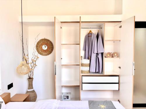a bedroom with a sliding closet with a robe at D'rei guesthouse in Canggu