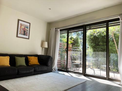 Una sala de estar con un sofá y una gran puerta corrediza de vidrio. en Spacious Family Townhouse near Kingston & Manuka, en Fyshwick