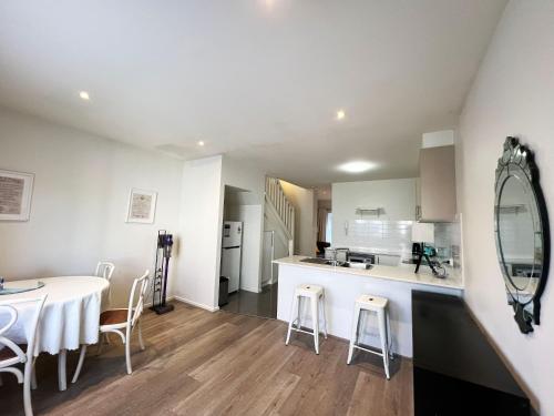 cocina y comedor con mesa y espejo en Spacious Family Townhouse near Kingston & Manuka, en Fyshwick