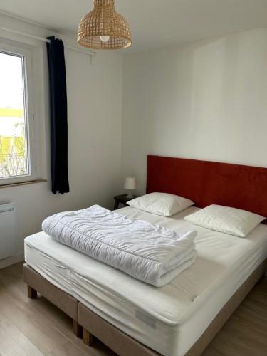 een slaapkamer met een groot bed met witte lakens en een raam bij Ile de Noirmoutier - Maison NO'VA refaite à neuf in LʼÉpine