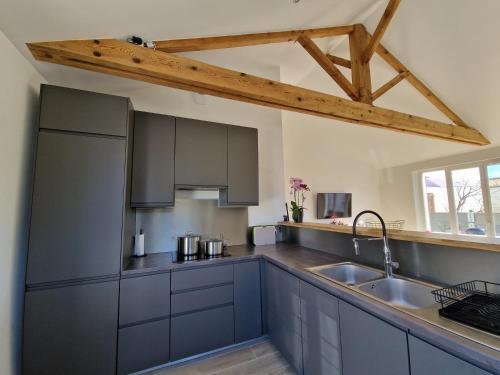 een keuken met blauwe kasten en een wastafel bij Ile de Noirmoutier - Maison NO'VA refaite à neuf in LʼÉpine