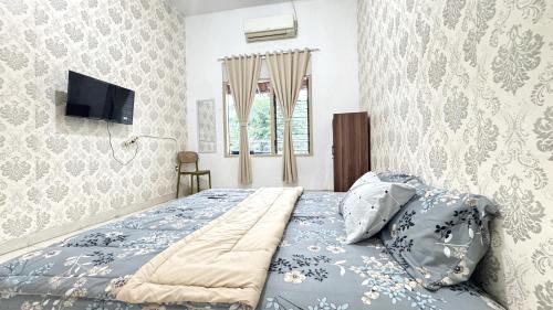 Postel nebo postele na pokoji v ubytování Homey Guesthouse Gubeng Syariah