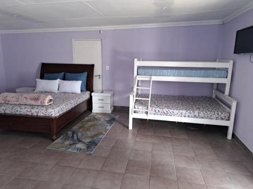 Nexus Guest House Alberton في ألبرتون: غرفة نوم بسريرين بطابقين وأرضية من البلاط