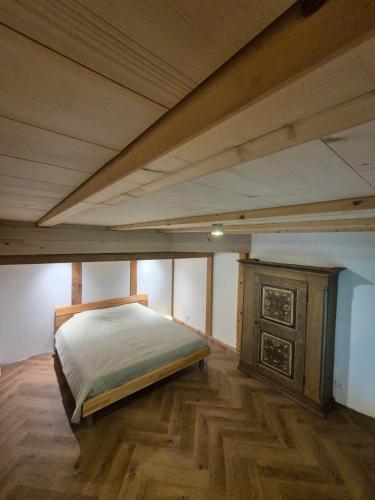 a large bedroom with a bed and a wooden floor at Kleine Heubühne im Emmental mit 2 Schlafzimmer und 2 Schlafsofas in Rüegsbach