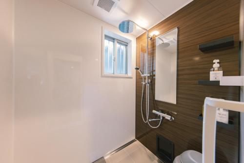 a bathroom with a shower and a toilet at Stay Okumatsusaka in Matsuzaka