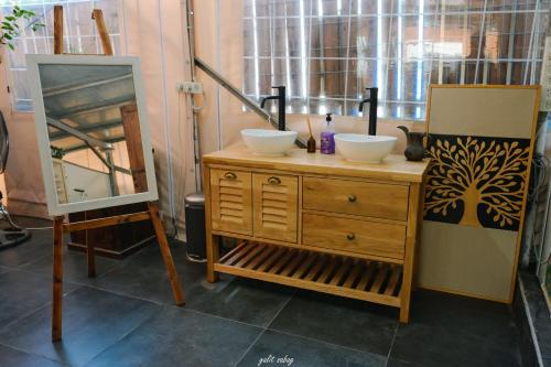 a bathroom with two sinks on a dresser with a mirror at חאן בשביל היער in Ta‘oz