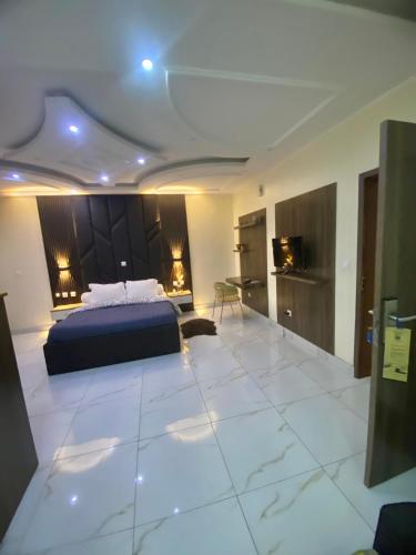 a bedroom with a bed and a tiled floor at Chambre meublée - Bonapriso in Douala