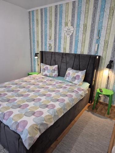 a bedroom with a bed and a green stool at Dream Studio Petrosani in Petroşani