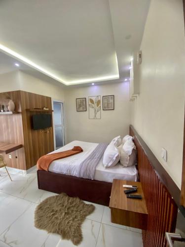 a bedroom with a bed and a table in it at Chambre meublée - Bonapriso in Douala