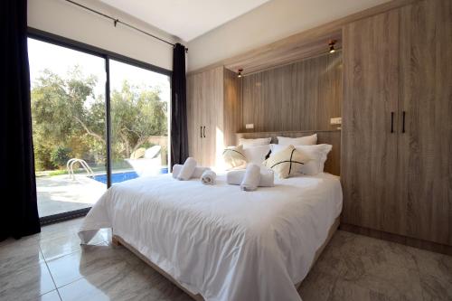 Un dormitorio con una cama blanca y una ventana grande. en Villa Blanca - Pureté & Modernité, en Essaouira