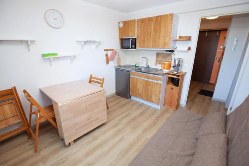Una cocina y una sala de estar con una mesa y un sofá. en Studio 1 chambre pied des pistes 24 m2, en Risoul
