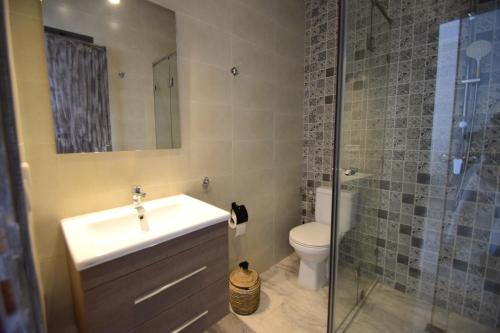 Un baño con lavabo, inodoro y ducha. en Villa Blanca - Pureté & Modernité, en Essaouira