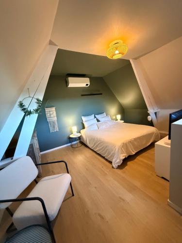 a bedroom with a bed and two chairs in it at Duplex neuf et cosy vue Mont des Cats in Météren
