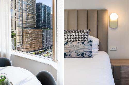 Un dormitorio con una cama y una ventana grande. en Modern Apartments Step from Quay west Sebel, en Sídney