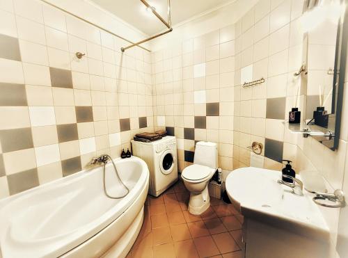 um banheiro com banheira, vaso sanitário e pia em Kyiv Sakura Apartment em Kiev