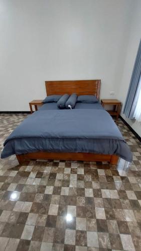 a bedroom with a bed and a checkered floor at See Sea Hostel & Resto in Jepara