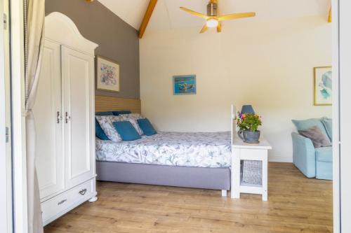 a bedroom with a bed and a ceiling fan at Woubrugge Logies in Woubrugge